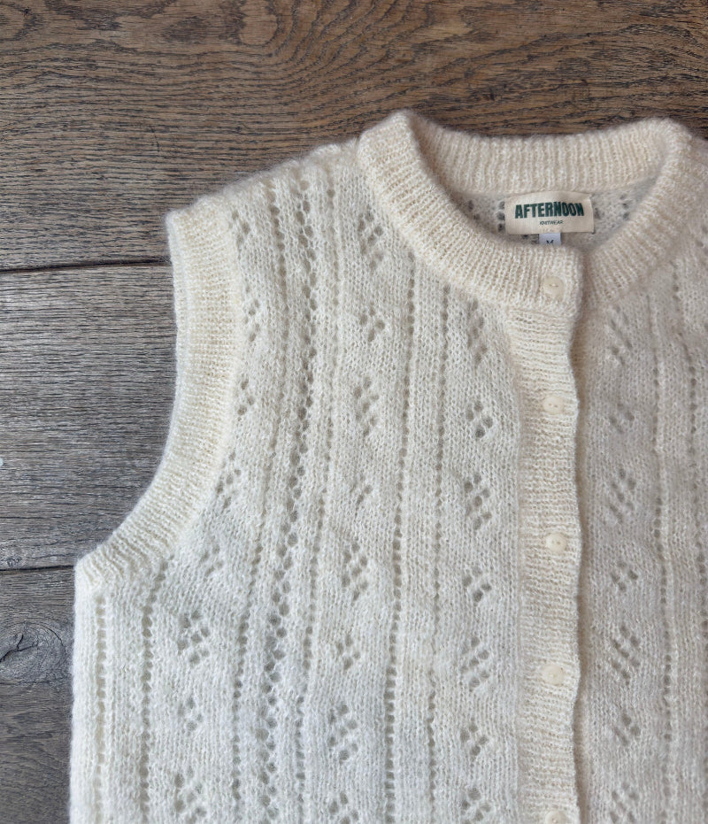 Cream-colored Mohair pointelle knit vest with a subtle pattern on a wooden surface, featuring the brand 'Afternoon'.