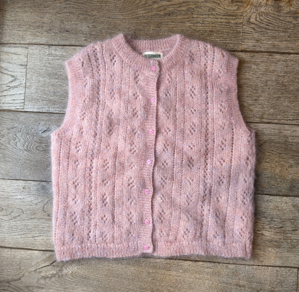 Pink Mohair pointelle knit vest on a wooden surface
